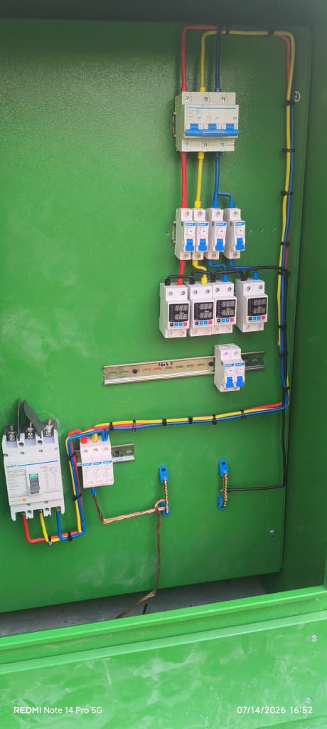 Wired electrical control panel mounted inside a green enclosure