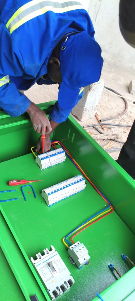Technician labelling components inside an electrical control panel