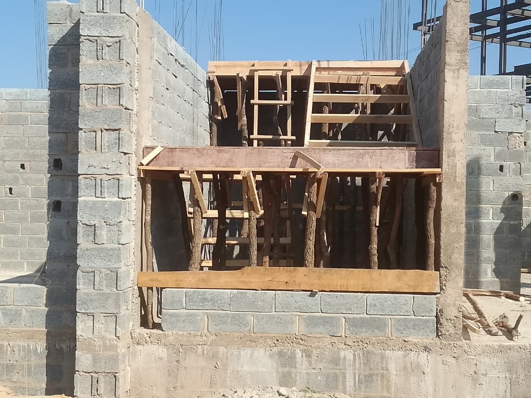 Timber window formwork set into fresh blockwork walls against blue sky