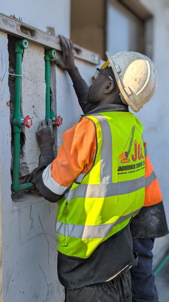 JCL technician checking plumbing pipework levels inside a finished unit