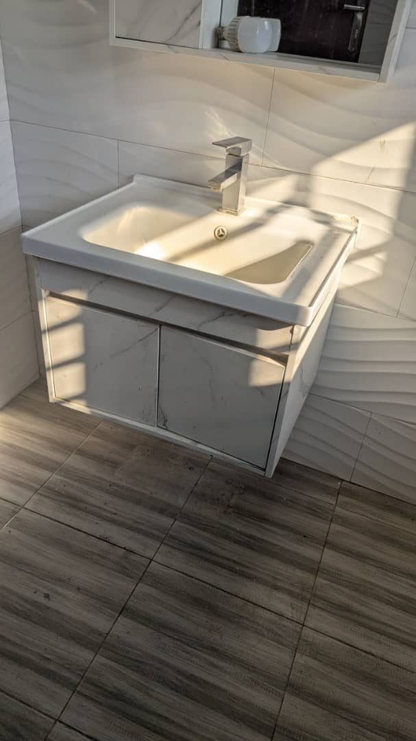Wall-hung marble vanity unit with modern tap in a finished bathroom